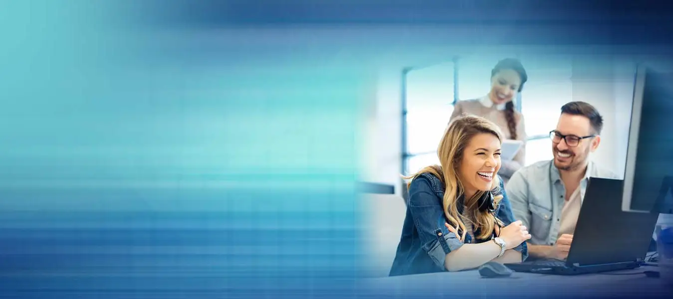 Three coworkers smiling at computer